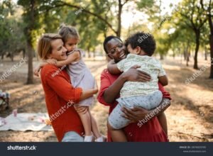 madre abrazando a hijos en parque