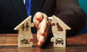 manos separando una casa y objetos personales