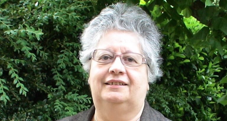 mujer mayor sonriente con documentos y anses