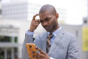 persona mirando su telefono confundida