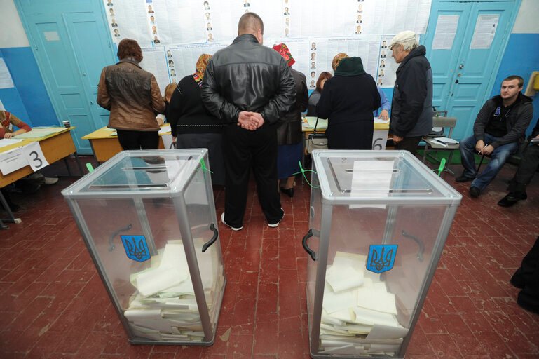 personas votando en urna parlamentaria